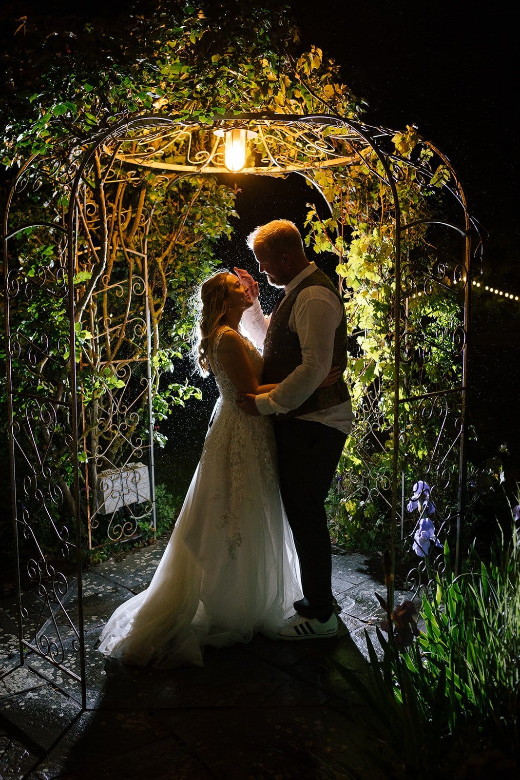 Bride and Groom Under floral arch at nighttime