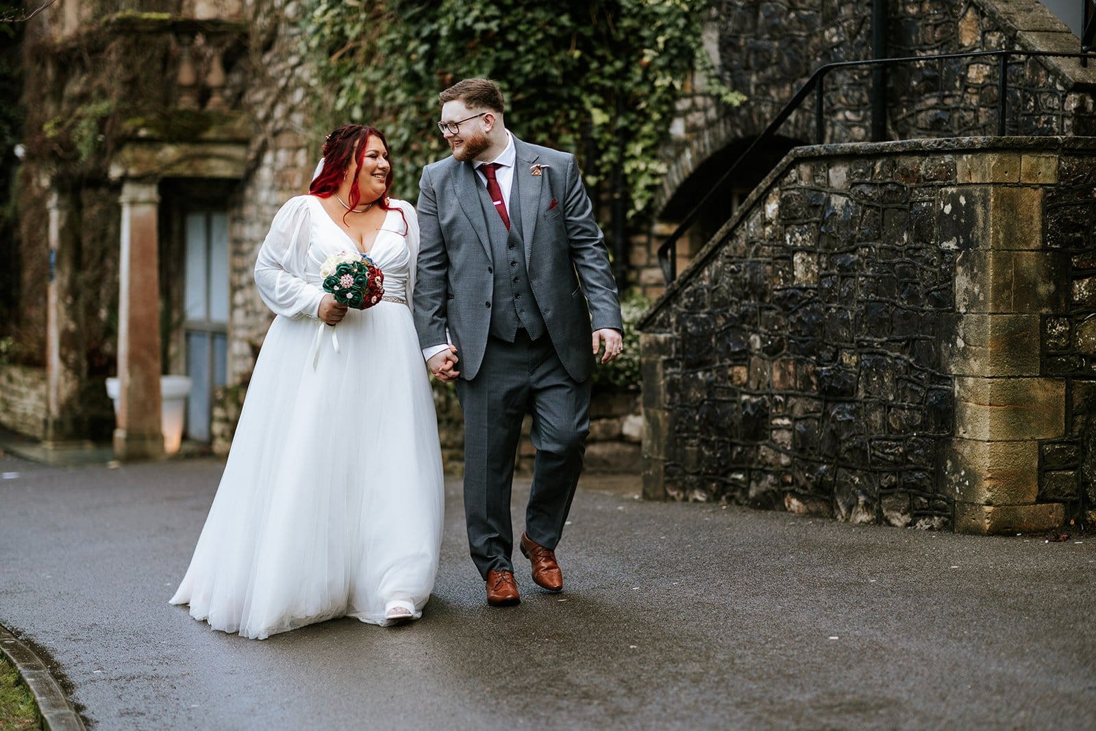 Couple walking hand in hand outdoors.